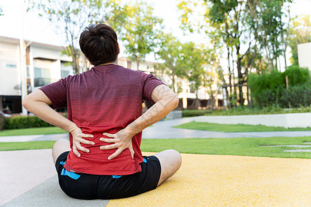 男性运动员背部疼痛和受伤 在公园跑步后手抓回或腰部脖子治疗赛跑者疾病十字形女性肌肉伤害脊柱按摩背景图片
