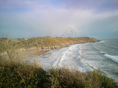 在英国威尔士的卡斯威尔湾海滩 即将涨潮 从到日落 海浪拍打沙滩的壮丽景色图片