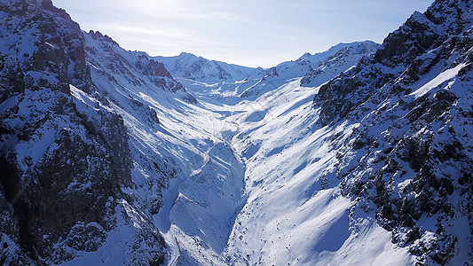 高雪山 树苗生长于一些地方山峰山脉晴天蓝色悬崖森林地标世界雪崩顶峰图片
