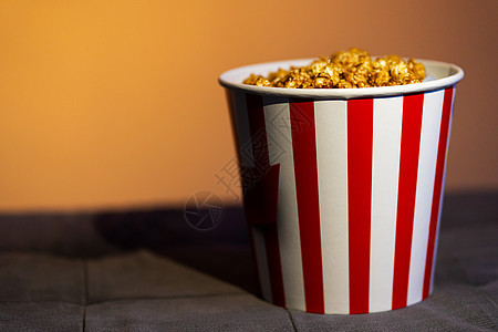 软沙发上一桶爆米花 该看有趣的了流行音乐乐趣玉米电视杯子房间纸板食物电影剧院图片