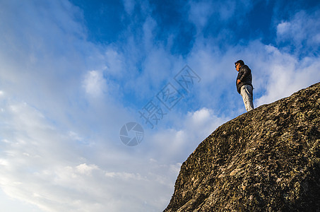 年轻人站在悬崖脚下 看着地平线图片