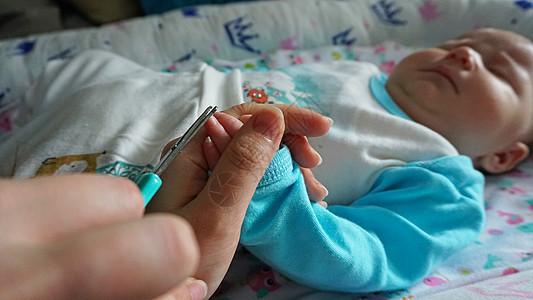 新生儿的指甲用剪刀切开美甲父母卫生宏观手指女性婴儿家庭新生身体图片
