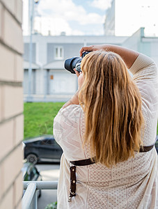 超重女性在户外用照相机拍照的肖像公园城市相机爱好身体头发女士摄影师街道成人图片