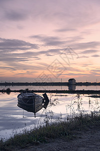 日落时在湖上的小船海岸家禽反思反射社区地标公园日出地平线旅游图片