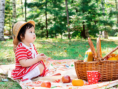 穿红裙子的小可爱宝宝 在公园野餐上戴白袜帽孩子小吃幸福家庭食物童年女孩快乐母亲闲暇图片