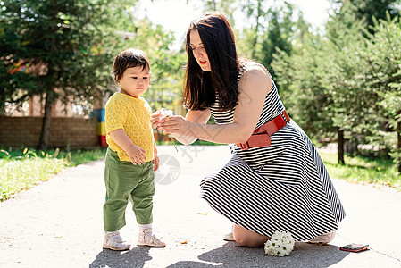 母亲在公园里走着她的女儿 给女儿送花幸福父母女性快乐闲暇妈妈孩子童年乐趣成人图片