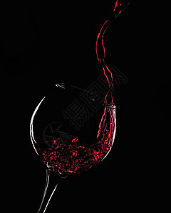 一杯红酒喷在玻璃杯里图片