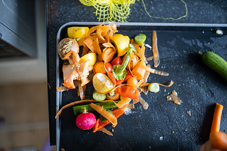 小有机垃圾堆在黑托盘的角落上橙子柠檬蔬菜萝卜食物水果绿色胡椒皮肤饮食图片