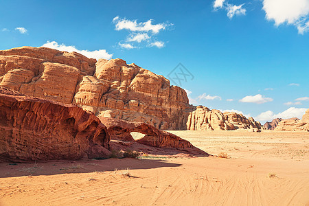 红沙沙漠上的岩石地块 小石弧桥 明亮的蓝天背景 — 约旦瓦迪拉姆的典型风景图片
