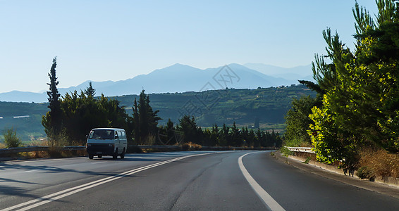 汽车在希腊克里特的路上和后面山上行驶图片