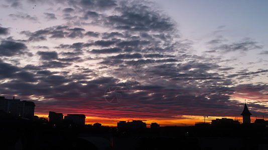 云层火灾日出 有背面建筑和阴云的天空 月亮是火的风景橙子城市天际太阳蓝色景观红色阳光黄色日落图片