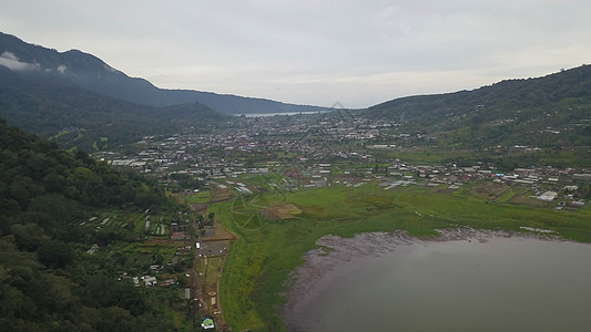 从巴厘布扬湖山丘的湖和山地观测到的无人驾驶飞机对湖上空天空太阳晴天蓝色地标树木森林岩石旅游热带图片