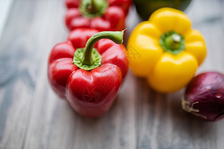 木制桌上的红色和黄色胡椒营养饮食食物蔬菜团体绿色沙拉洋葱萝卜西红柿图片