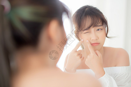 美丽美丽的年轻亚洲女人 看着镜子的镜像是Acn卧室护理女孩身体青少年皮肤治疗手势化妆品保健图片