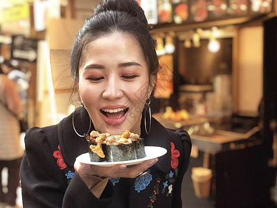 观光女游客展示牛肉寿司 最流行的美味食品海鲜盘子海洋寿司蔬菜动物扇贝烹饪店铺餐厅图片