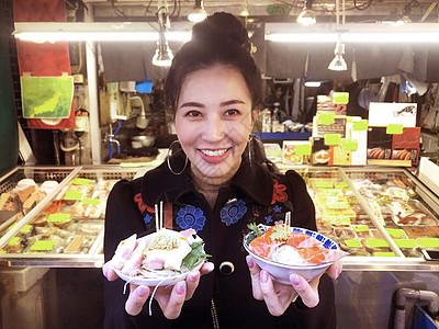 旅游女游客展示了最流行的美味食品 食用马哈鱼生鱼鱼肉图片