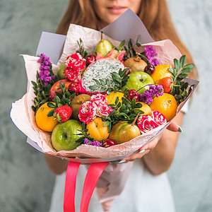 在女性手中吃花束花朵成人橙子奇异果营养水果女士桉树美食女孩图片