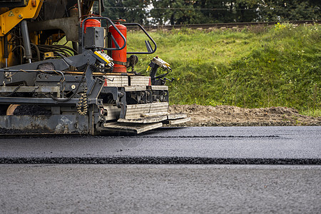 在道路建设工地铺设新鲜沥青的工业沥青帆机压力车辆机器街道振动器劳动者车道终结者装载机运输图片