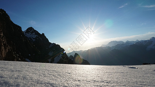 雪地高山的黎明旅游旅行荒野爬坡冰川顶峰风景蓝色太阳森林图片