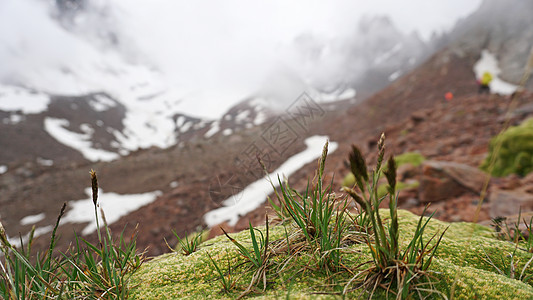 雪山和绿苔的云层很大草地游客旅行天空苔藓蓝色石头风景远足环境图片