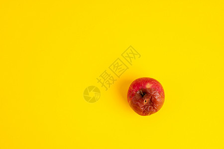 黄色背景制服上有蠕虫的旋转苹果皱纹食物腐烂厌恶水果模具宏观衰变老化皮肤图片