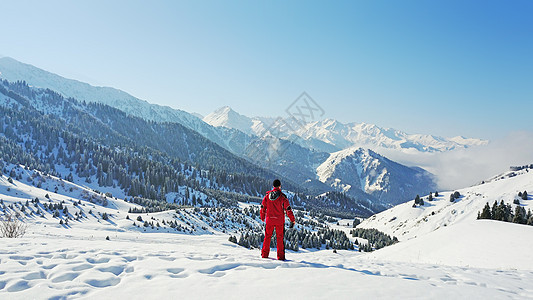 那家伙看着雪山和云彩冒险天空顶峰小路森林自由背包闲暇丘陵悬崖图片