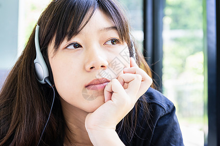 带耳机和听音乐的青少年女孩学习娱乐说谎房间班级房子女士药片音乐闲暇图片