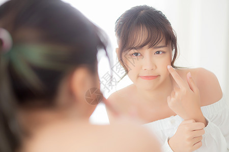 肖像美丽的亚洲年轻女性照镜子是痤疮 青春痘治疗 女孩问题美容脸 完美地与家里卧室的健康相结合 具有皮肤护理和保健概念图片