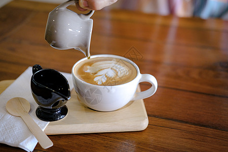 热辣卡布奇诺莫查咖啡加拿铁艺术杯子桌子咖啡牛奶拿铁饮料食物咖啡店奶油图片