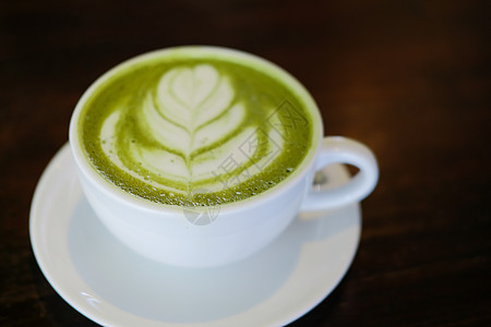 热辣的日本火柴 绿色茶加拿铁艺术牛奶饮料杯子咖啡桌子奶油抹茶咖啡店食物图片