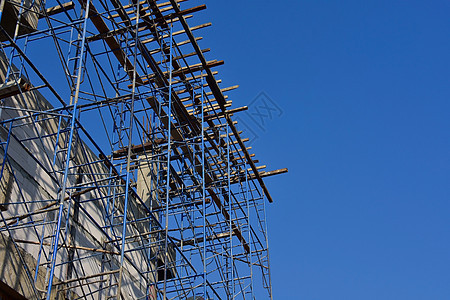 正在建造的一栋大楼上架脚架电缆天空车站电气脚手架传播电压金属蓝色网络背景图片
