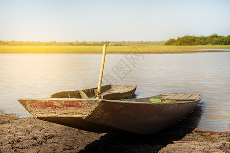 木船停在河上 干旱时有水钓鱼热带木头海岸旅行太阳海滩海浪蓝色天空图片