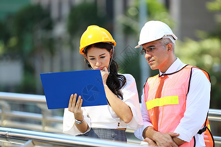 土木工程 建筑工程师在建筑工地或高层建筑工地与建筑师讨论 并进行轮廓规划测量帽子头盔安全安全帽建筑学工厂会议项目经理团队图片