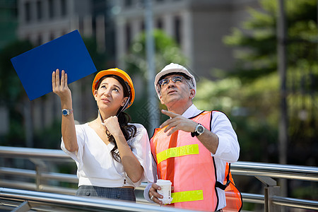 工程师和商务人士举高五反对建设 工程 建筑 城市生活和未来的概念帽子蓝图经理商业合作男性职场绘画建筑学承包商图片