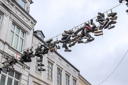 在德国最北边的小镇 名叫弗伦斯堡的老房子之间挂着鞋子建筑鞋类吸引力艺术品天空金属运动鞋阳光建筑学旅行图片