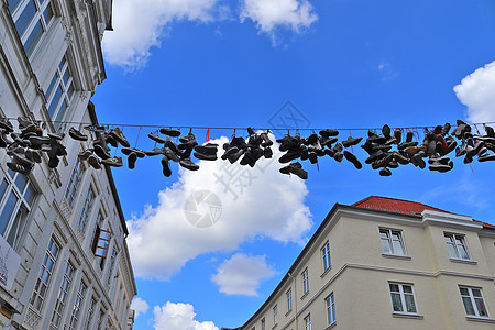 在德国最北边的小镇 名叫弗伦斯堡的老房子之间挂着鞋子旅游建筑学运动鞋建筑物建筑阳光旅行蓝色蓝天艺术品图片