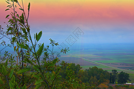 山谷 彩色天空和浅地的灌木树枝图片
