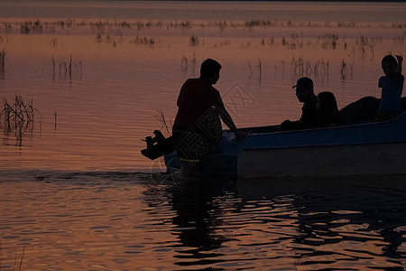 渔船附近河上渔民的轮椅 推着船食物钓鱼生活海滩反射男人房子渔夫日落木头图片