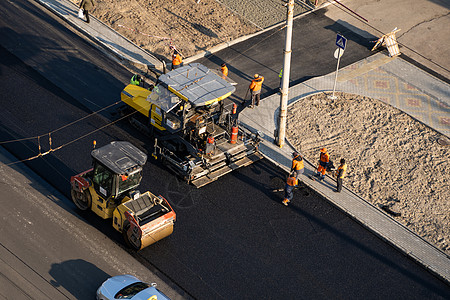 10 2020 带有重型振动压路机的重型沥青压路机在街道上的道路施工现场压上新的热沥青和沥青摊铺机振动卡车建筑工程铺路机器活动操图片