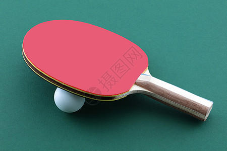 绿桌乒乓球桨上的网球蝙蝠和白球图片