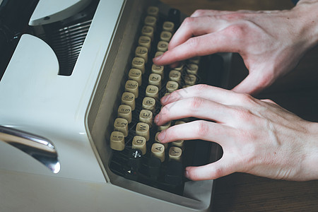 男人正在打一个老式打字机的打字机新闻业作家打印乡村博客作者创造力写作记者评书图片