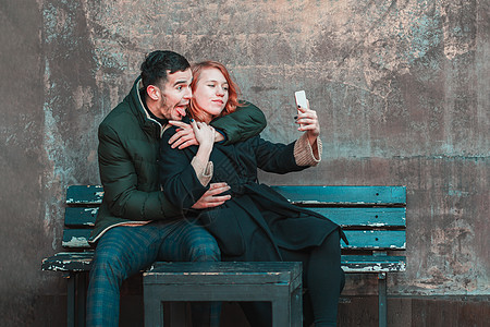 快乐的情侣在二位上自以为是手机幸福女孩女性照片夫妻乐趣喜悦女士青少年图片