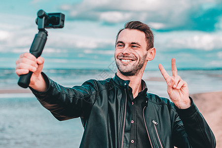 帅哥在海滩自以为是微笑自拍视频照片录像稳定性旅游男性互联网男人图片