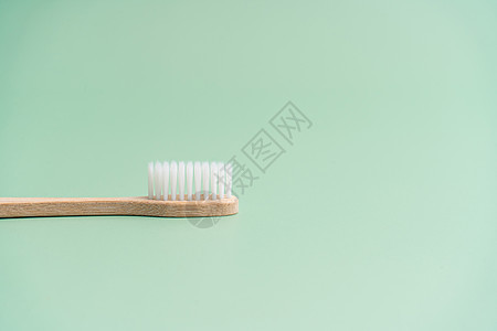 浅绿色背景的环保竹木抗菌牙刷刷子卫生牙医生态回收纤维木头牙膏工具材料图片