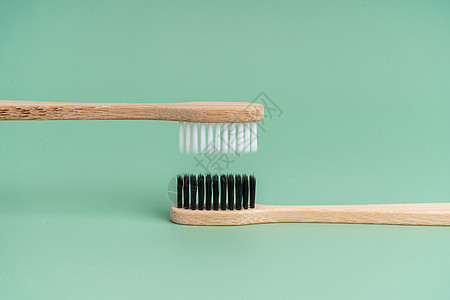 浅绿色背景上有白色和黑色刷毛的两把环保抗菌竹木牙刷 保护环境是趋势 宽容 复制空间卫生工具木头刷子生态牙科口服生活牙医浴室图片
