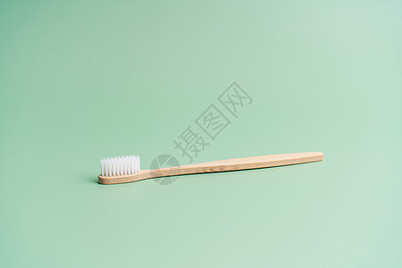 浅绿色背景的环保竹木抗菌牙刷口服牙膏卫生刷子牙科回收材料生态工具生物图片