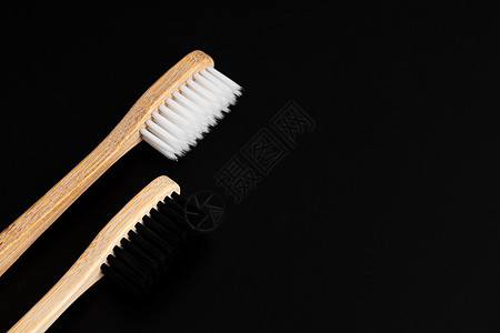 黑色背景上有白色和黑色刷毛的两把环保抗菌竹木牙刷 保护环境是趋势 宽容 复制空间牙科木头生物工具口服牙齿牙医卫生生活浴室图片