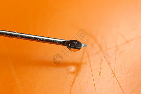 橙色背景下针针针头的滴水落下外科液体宏观科学器材医疗保健特写医学注射图片