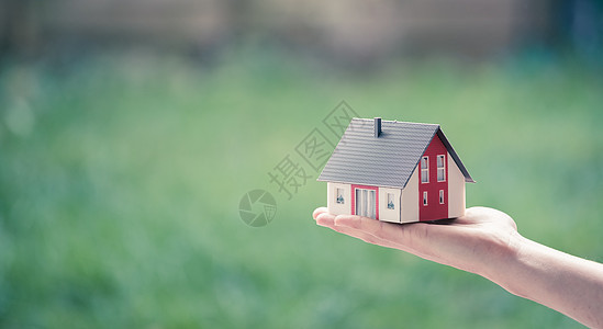 成人手握着红屋模型 户外 新住宅 财产和房地产的概念 文字空间装修居住家庭生活抵押邻里投资建筑学宽屏销售图片