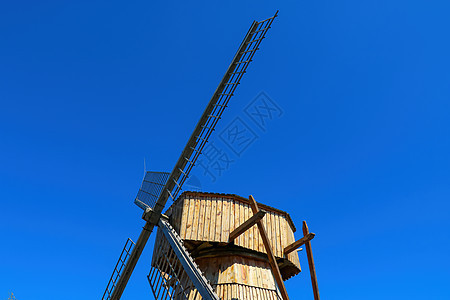 蓝天背景上的旧木磨坊的刀锋图片